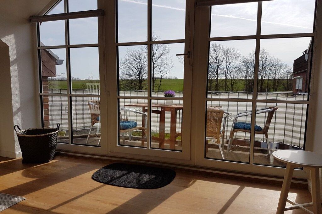 A room with a large sliding glass door leading to an outdoor patio area.