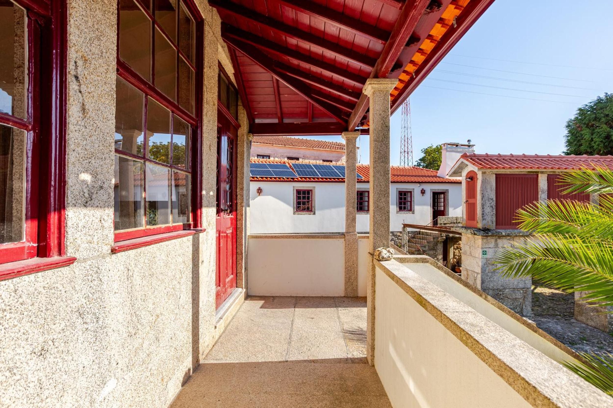 Un espace extérieur abrité, avec un chemin menant à un bâtiment dont le toit est équipé de panneaux solaires.
