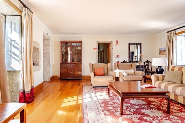A living room with a sofa set, a wooden coffee table, and a patterned rug.