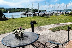Un puerto deportivo con barcos amarrados, un área verde y una mesa con un arreglo floral.