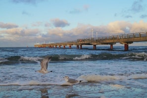 A pier extending into the water with waves crashing against it. - Holiday room with 1 bedroom (Ostseebad Prerow)