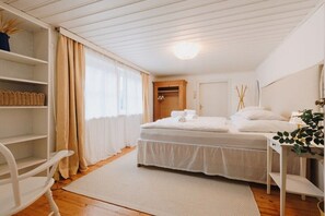 Ein Schlafzimmer mit Bett, Nachttisch, Stuhl, Kleiderschrank und Regaleinheit.