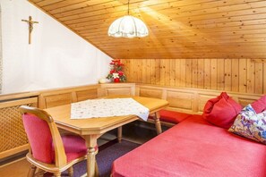 A wooden room with a bench, a table, and a bed. - Almgut Farm || Faistenau (Faistenau)
