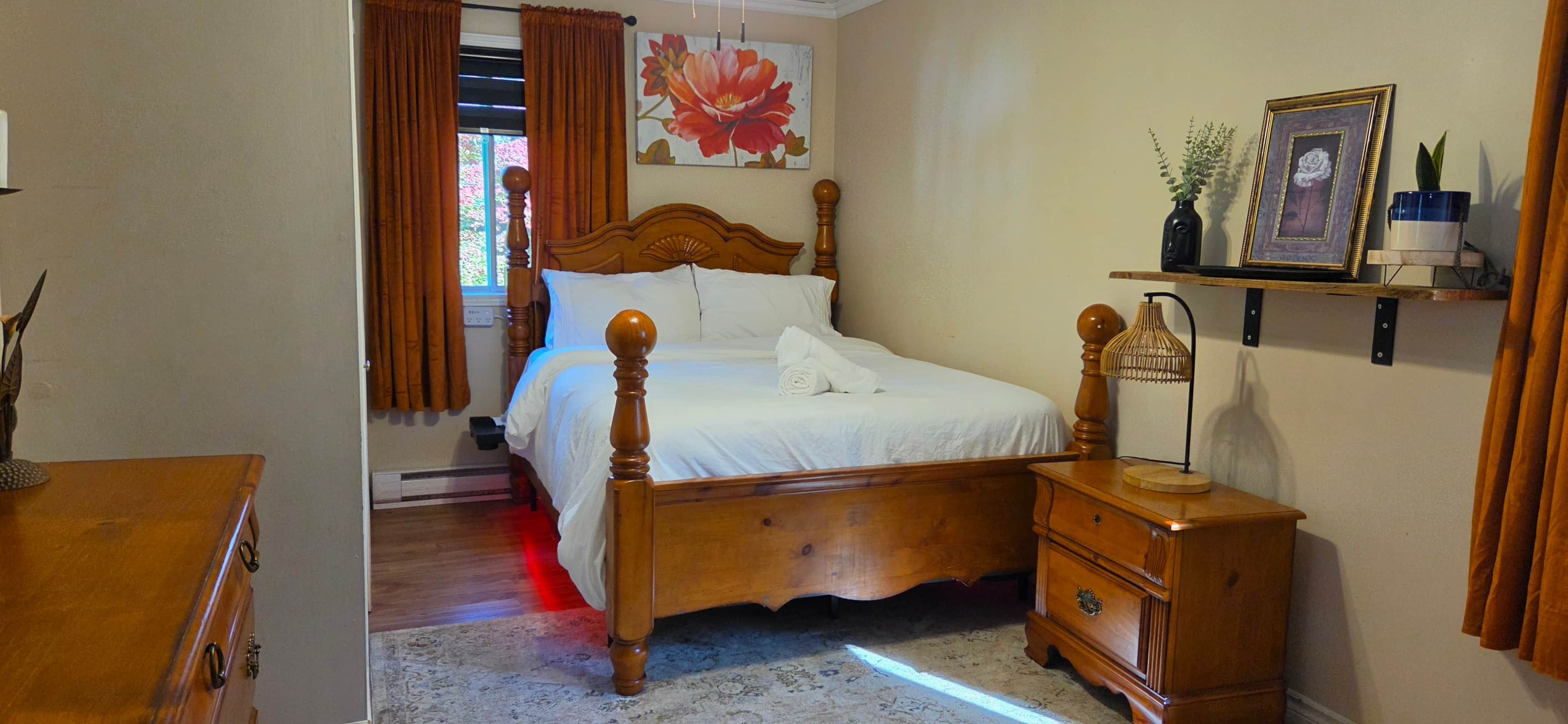 A bedroom with a wooden bed, a nightstand, a dresser, and a wall-mounted shelf with a vase and picture frame.