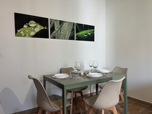 A dining table with four chairs, a set of plates, glasses, and cutlery. - Bonaria: Apartment for 6 | Fiera, City Center, and Poetto (Cagliari)