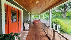 A covered porch with a wooden ceiling, a red door, and a white railing. - Mountain Views, Playroom, Fireplaces, Sleeps 8+! (Great Barrington)