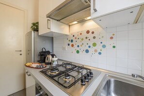 Eine Küche mit Gaskochfeld, Wasserkocher und Spüle.