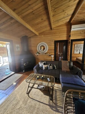 A cozy cabin interior with a sofa, a coffee table, and a fireplace. - 'Cabaña Mirador De Las Lagunetas' with Mountain View, Wi-Fi and Air Conditioning (El Estanco)