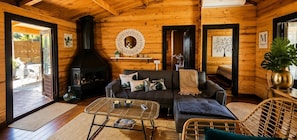A cozy cabin interior with a fireplace, a sofa, a coffee table, and wicker furniture. - 'Cabaña Mirador De Las Lagunetas' with Mountain View, Wi-Fi and Air Conditioning (El Estanco)
