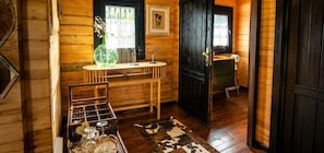 A wooden interior with a dining table, chairs, a vase with dried flowers, a black door, and a small cabinet. - 'Cabaña Mirador De Las Lagunetas' with Mountain View, Wi-Fi and Air Conditioning (El Estanco)