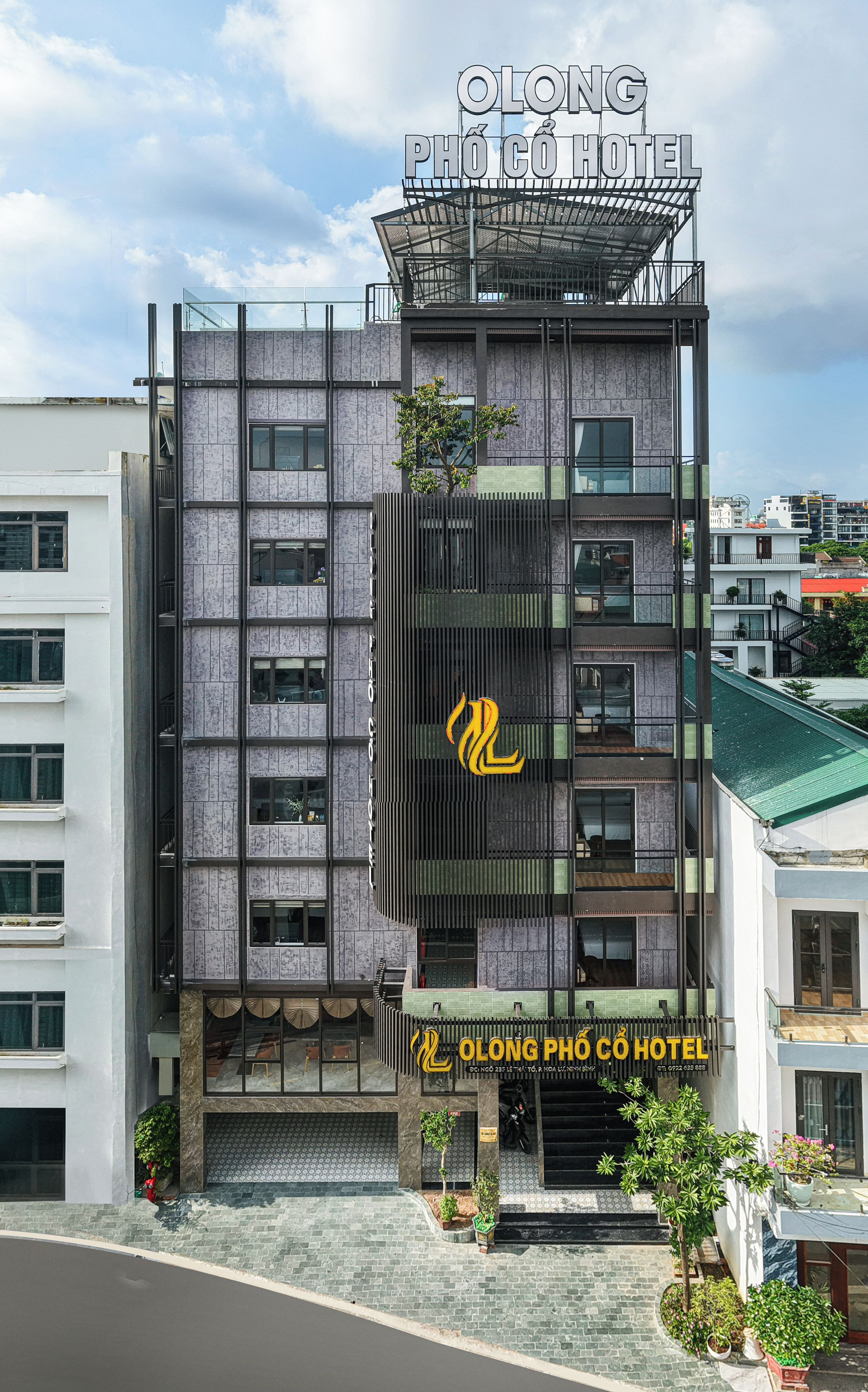 A modern hotel building with a prominent sign, multiple floors, and a visible logo.