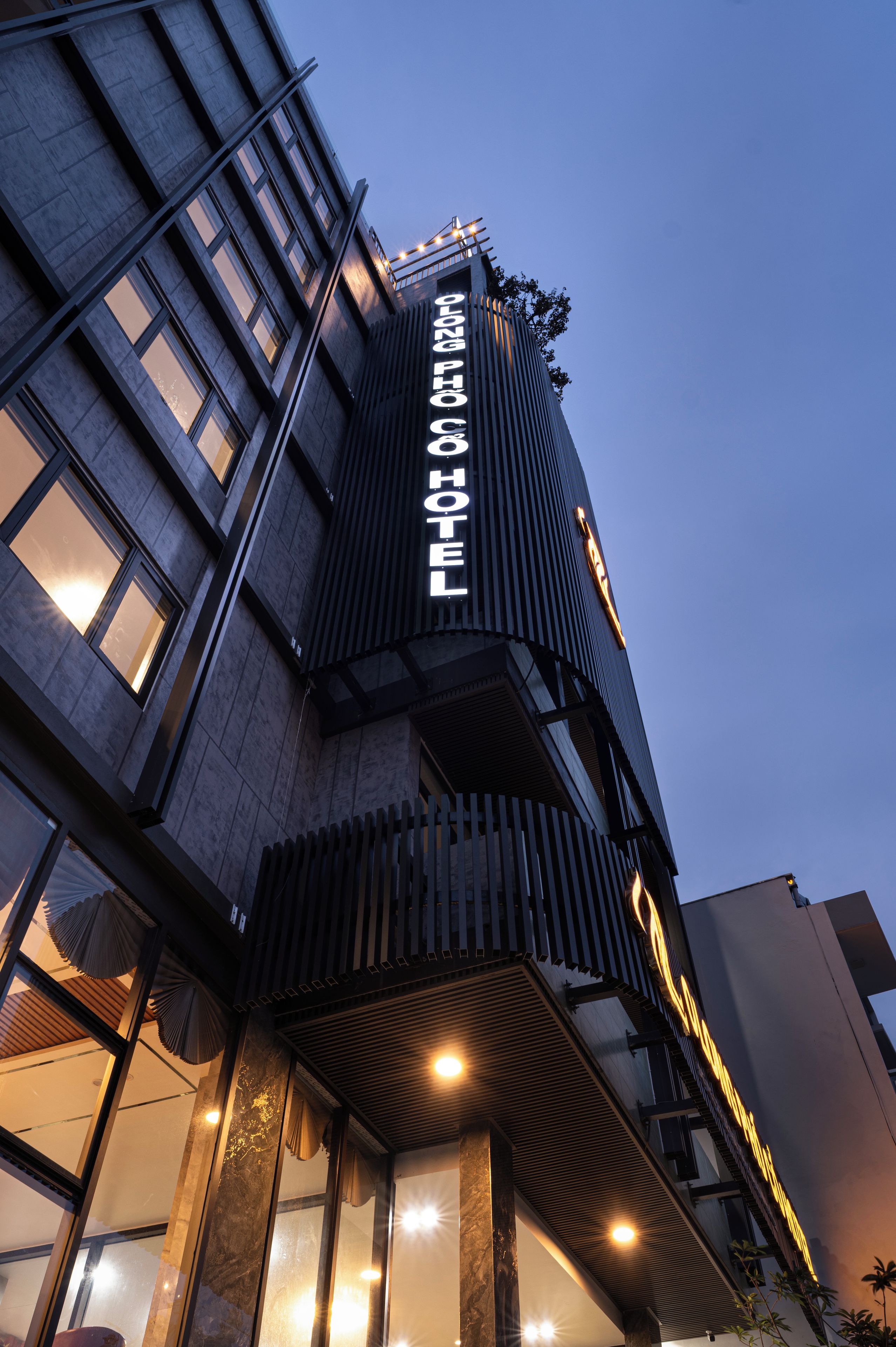 A modern building with a prominent vertical sign indicating a hotel.