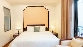 A hotel room with a large bed, two bedside tables with lamps, a chair, and a view of the outdoors.