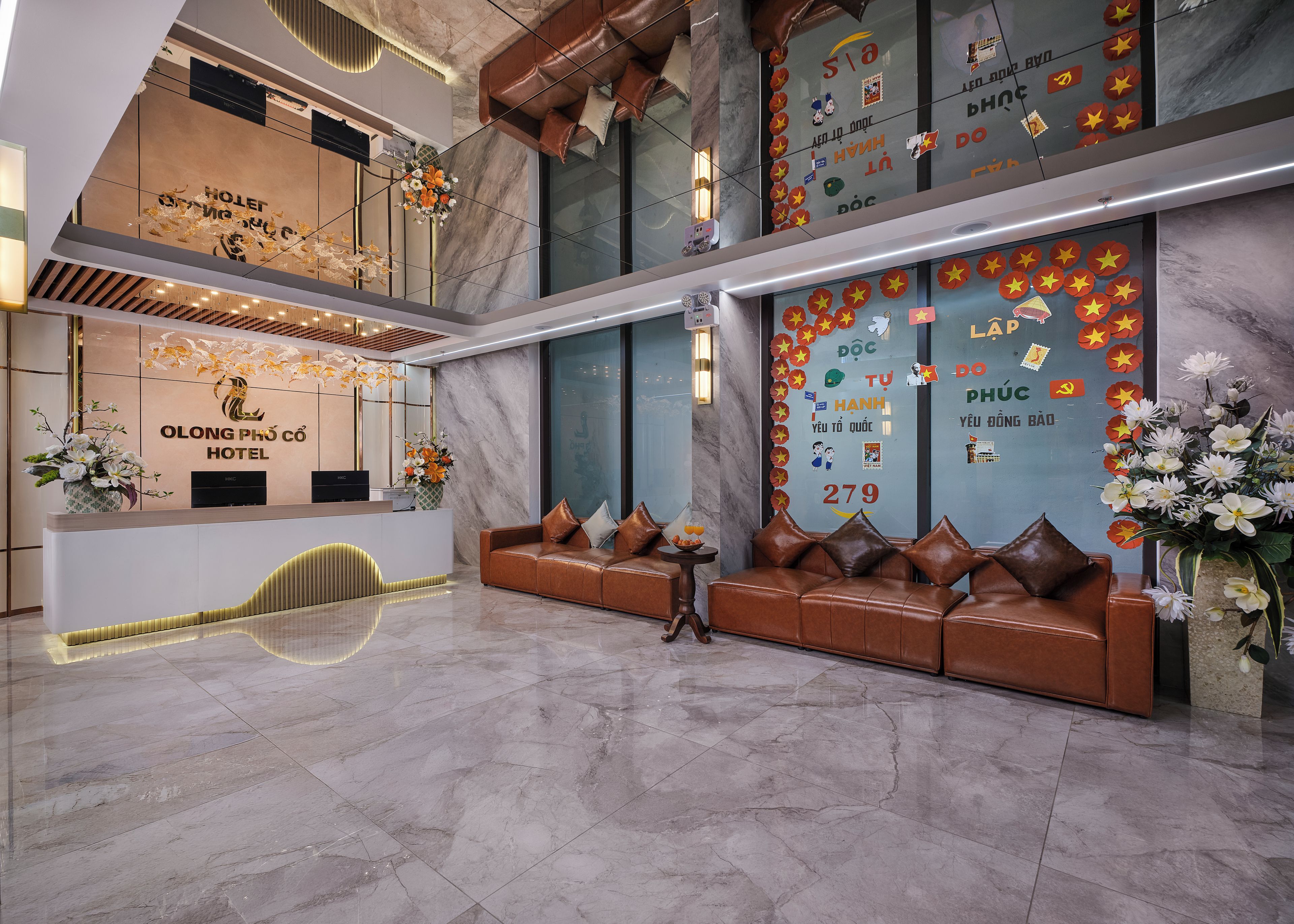 A hotel reception area with a reception desk, seating area, and decorative elements.