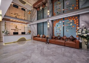 Zona de recepción de hotel con mostrador, área de estar y detalles decorativos.