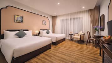 Une chambre d’hôtel avec deux lits, un bureau, une chaise, une télévision et une fenêtre avec des rideaux.