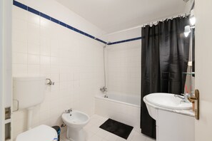 Un bany amb vàter, bidet, banyera i rentapel.