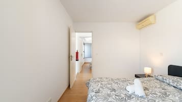A hotel room with a bed, bedside lamp, and a fire extinguisher.