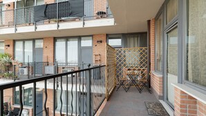 A balcony with a metal railing, a wooden lattice partition, and a small table with chairs. - GuestHost - Cozy Apartment in Milan (Milan)