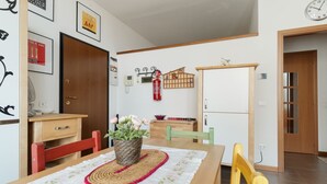 A dining area with a wooden table, chairs, and a potted plant. - GuestHost - Cozy Apartment in Milan (Milan)
