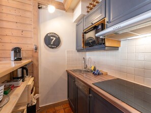 A compact kitchen with a wooden countertop, a built-in oven, a sink, and a clock on the wall. - Cosy 1 Bedroom - Arc 1940 - Hameau du Glacier (Arc 1950)