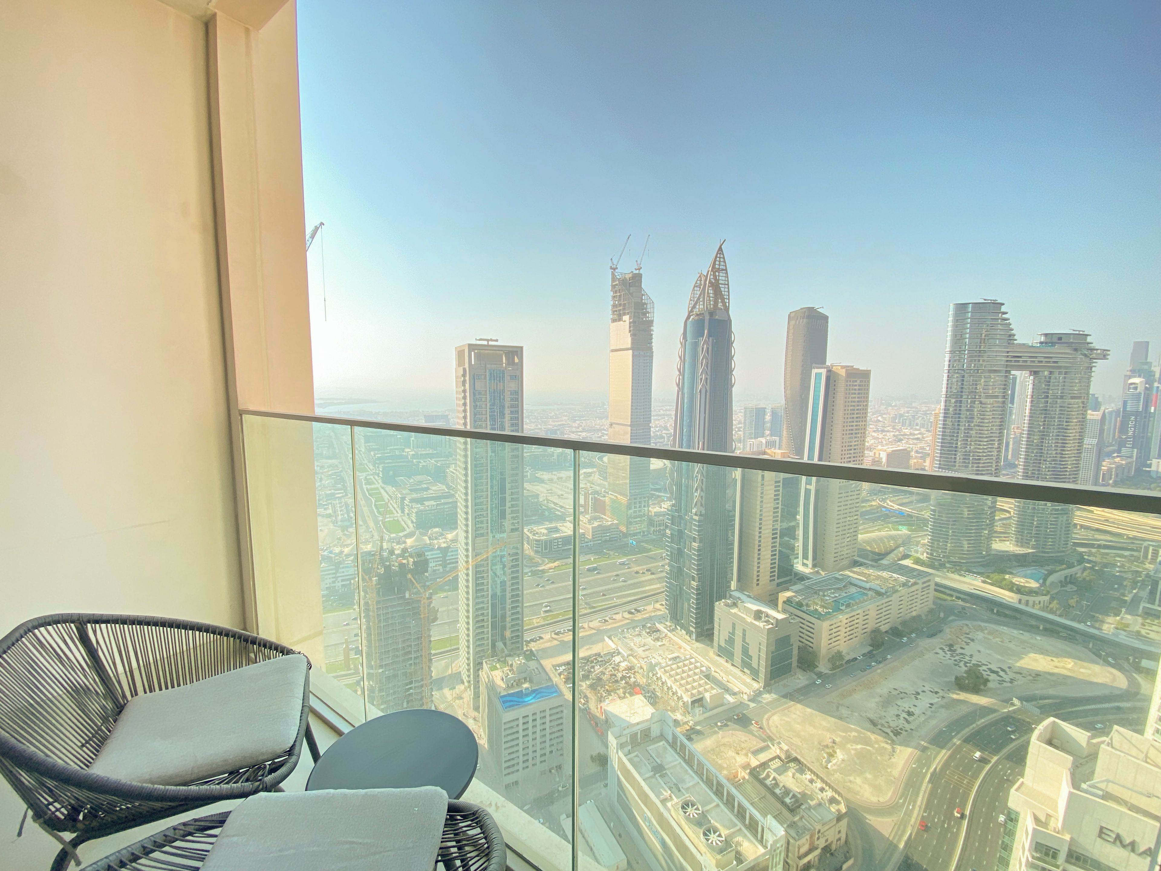 Ein Balkon mit Blick auf eine Skyline, darunter Hochhäuser und eine Straße.
