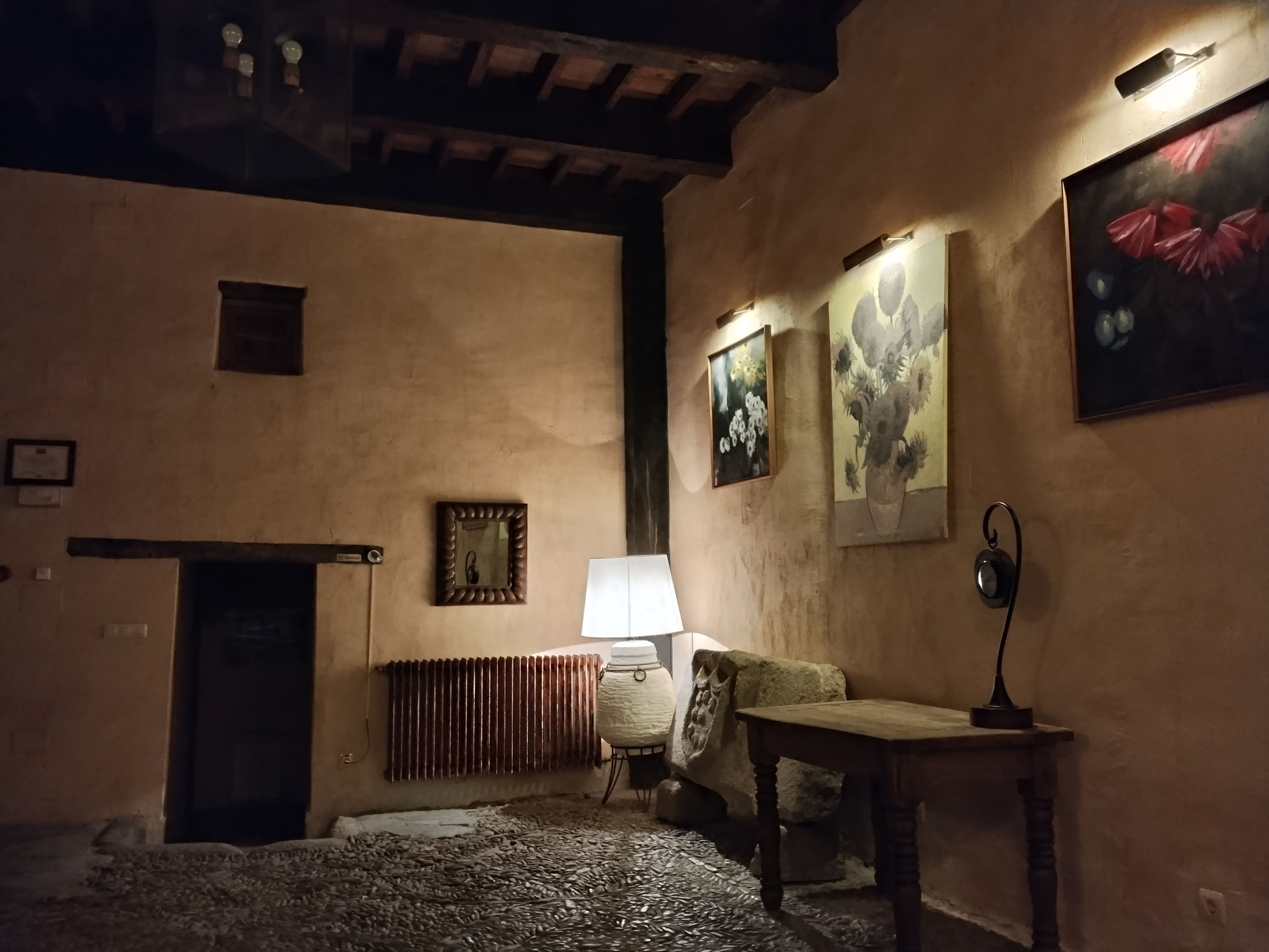 A dimly lit room with a radiator, a table, and a lamp.