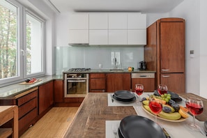 Una cocina moderna con comedor, que incluye estufa, horno y un amplio armario de madera.