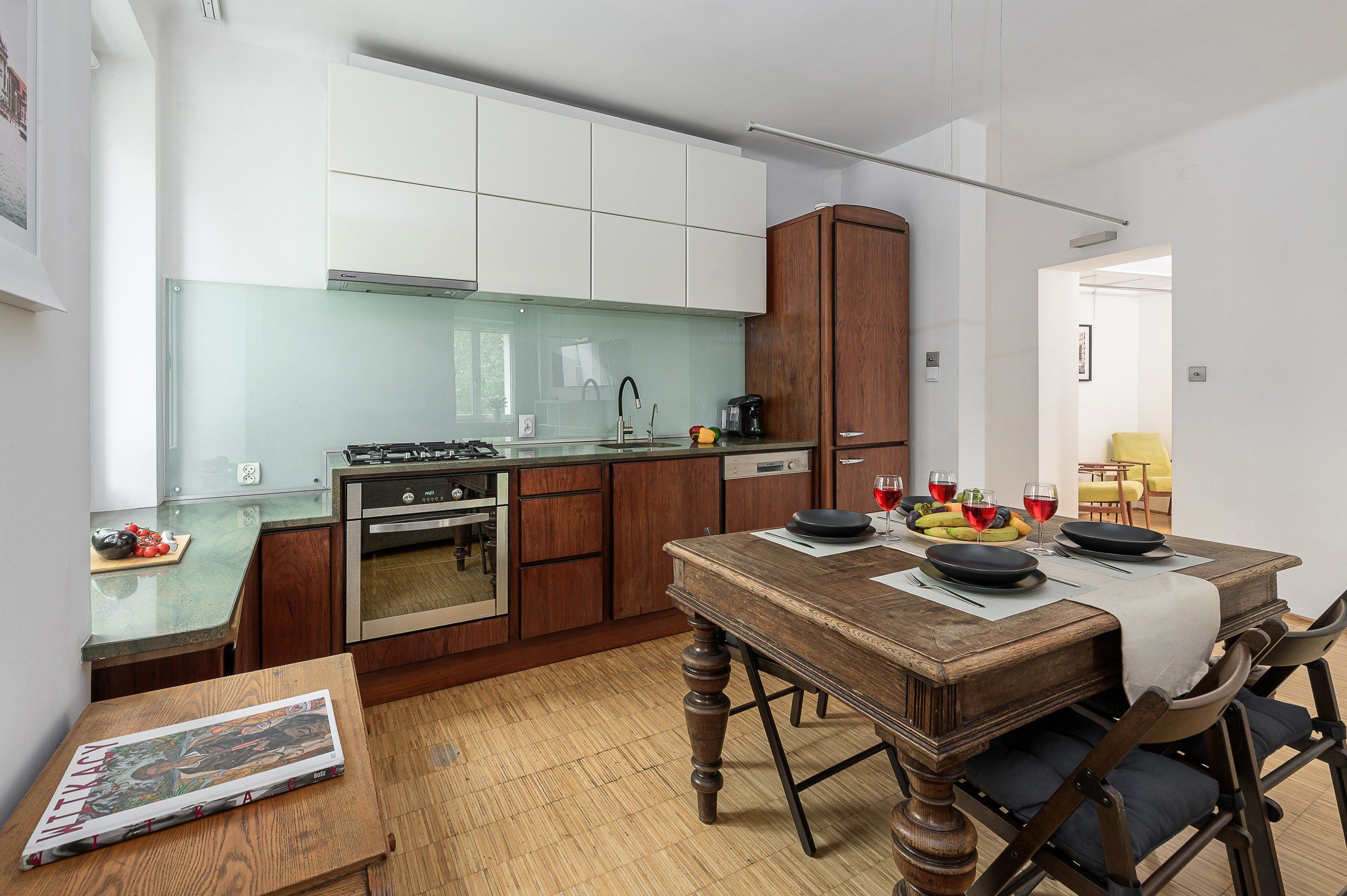 A compact kitchen with a dining area, a built-in oven, and a coffee maker.