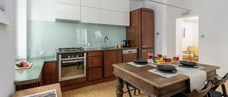 A compact kitchen with a dining area, a built-in oven, and a coffee maker.