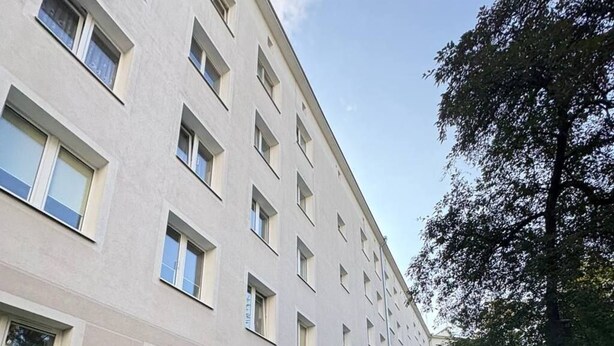 Ein mehrstöckiges Gebäude mit einem Ziegelweg, der zum Eingang führt.