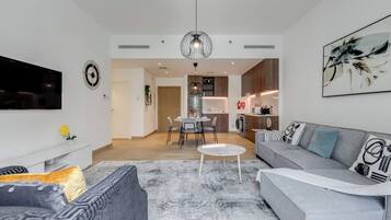 A modern living room with a grey sofa, a coffee table, and a flat-screen TV.
