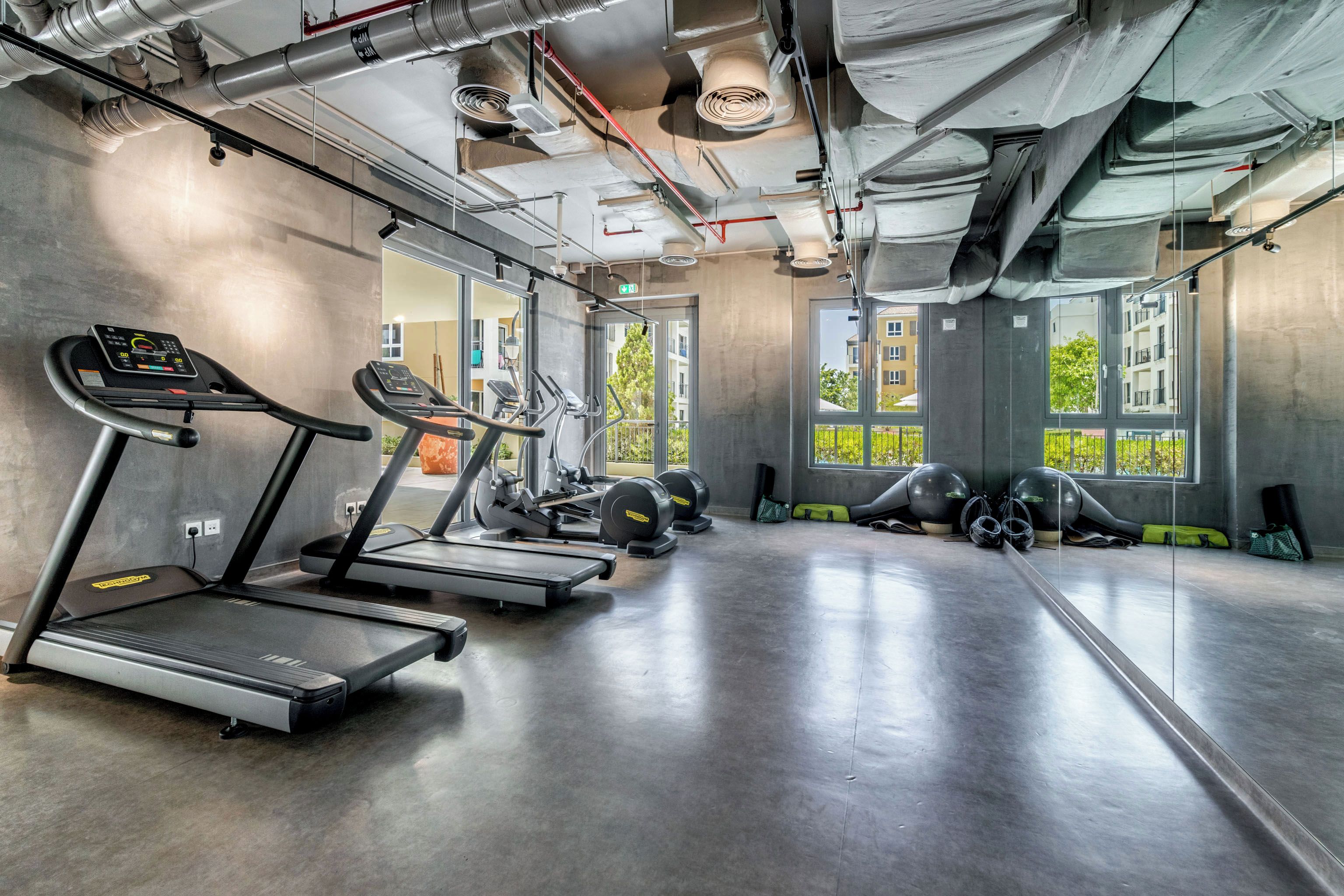 A gym with treadmills, elliptical machines, and weight equipment.