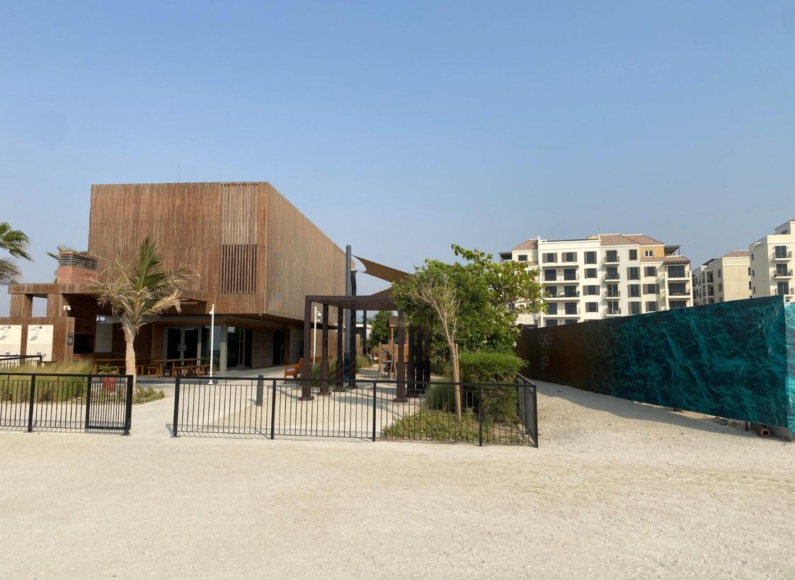 Un bâtiment moderne doté d’un toit plat et d’une grande porte d’entrée.