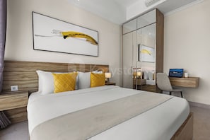 Ein Hotelzimmer mit einem großen Bett, einem Nachttisch, einem Schreibtisch mit Stuhl und einem Spiegel.