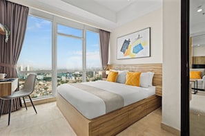 Ein modernes Hotelzimmer mit einem großen Bett, einem Schreibtisch und einem Stuhl.
