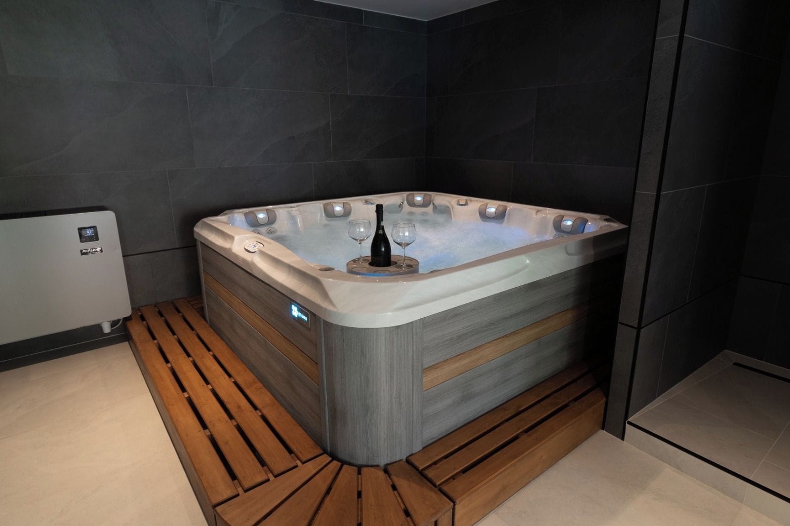 Un baño moderno con bañera exenta, suelo de listones de madera y calefacción integrada.
