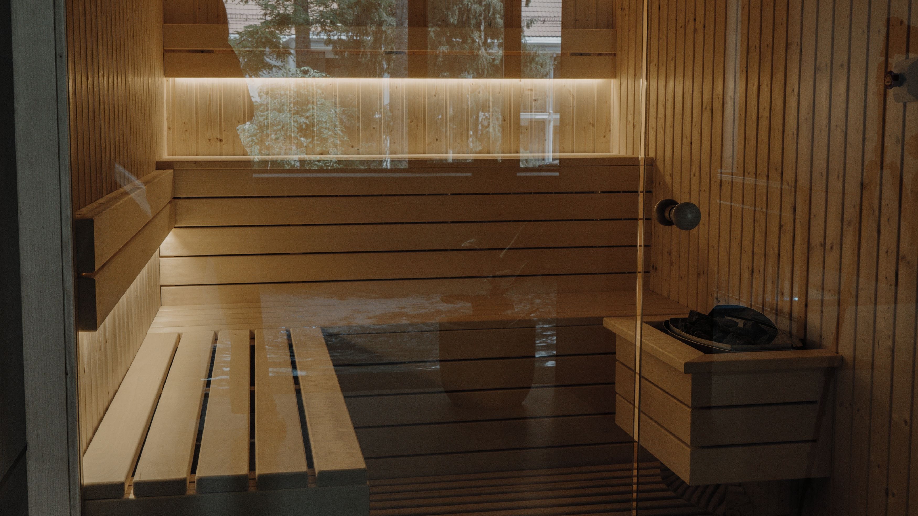 Una sauna con bancos de madera y un banco con toalla.