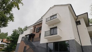 A modern two-story building with a wooden facade, a balcony, and a staircase. - Arbor Hotel (Sovata)
