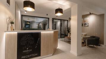 Een hotel receptie met een receptiebalie, twee hanglampen en een modern interieur.