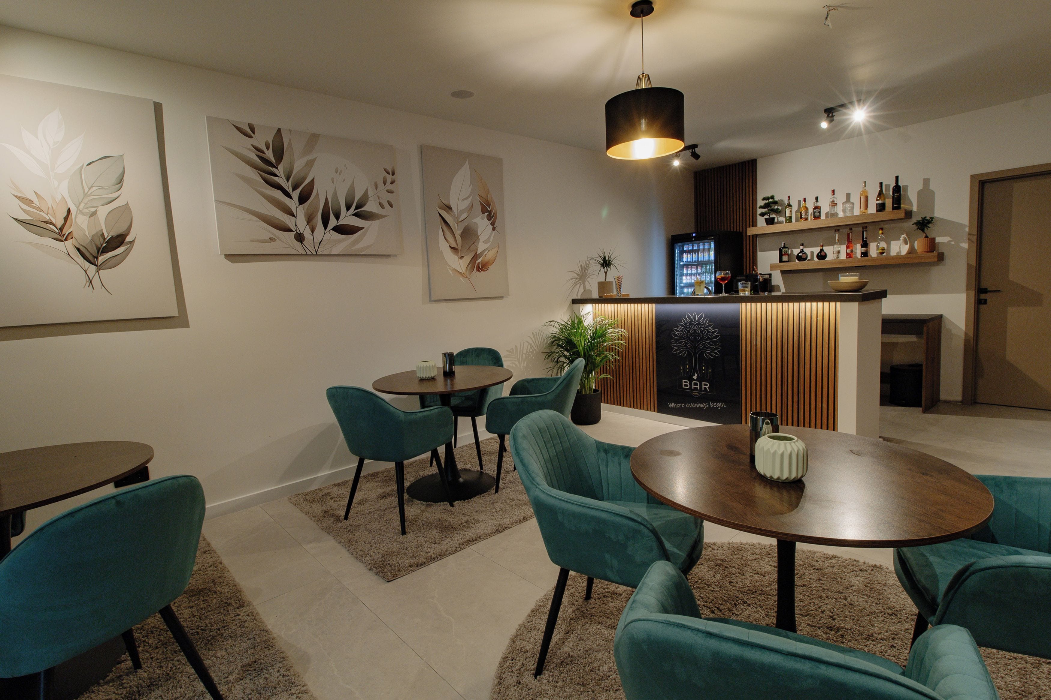 A modern interior with a bar area, seating, and artwork on the walls.