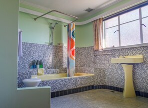 Ein Badezimmer mit einer Badewanne, einem Waschbecken und einem Fenster.