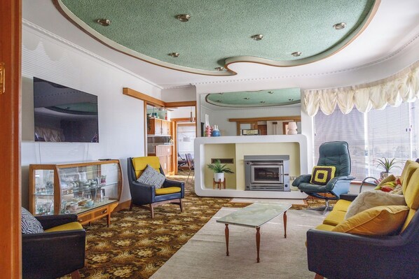 Ein Wohnzimmer mit Kamin, einer Couch, einem Couchtisch und einem Fernseher.