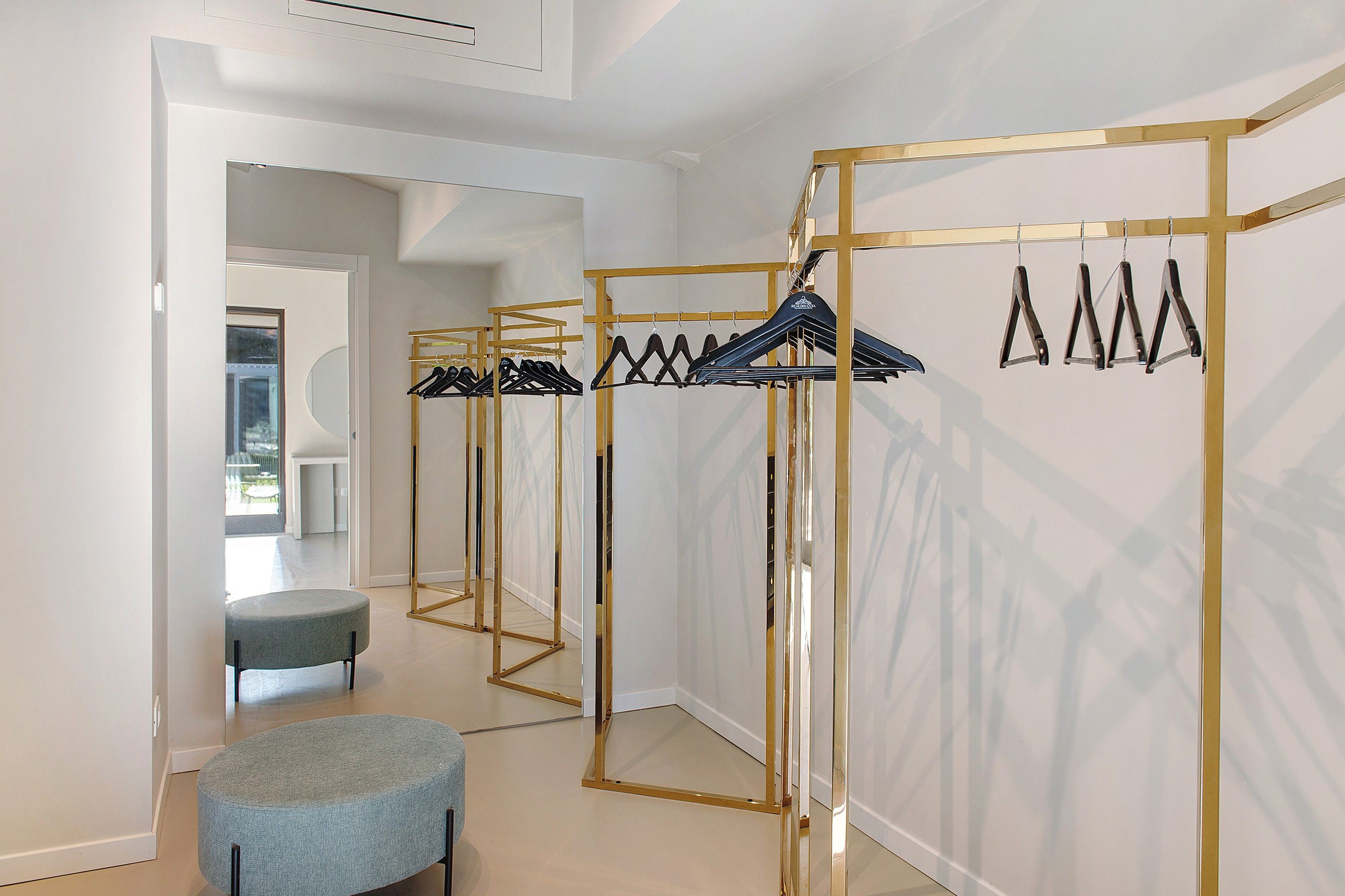 A hallway with a mirrored closet and a seating area.
