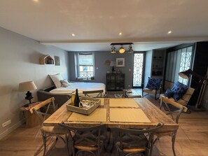 Una sala acogedora con cama, mesa de comedor y sillas.