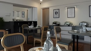 Et moderne spiseområde med et langt bord, stole og en vandflaske.