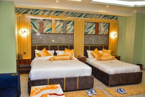 A hotel room with two beds, a large mirror, and a decorative wall. - Naks Palm Hotel (Nakuru)