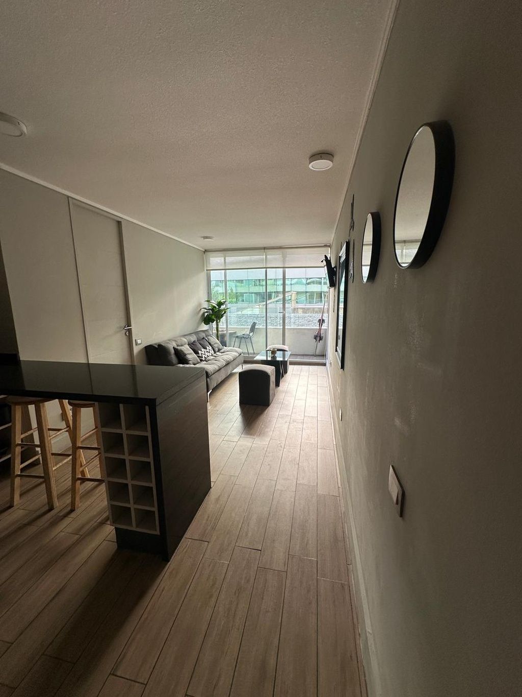 Una sala de estar moderna con un sofá, una mesa de centro y un comedor con una mesa y sillas.
