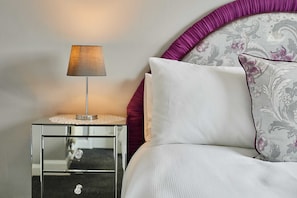 A neatly made bed with a white pillow and a decorative pillow with a floral pattern. - Host & Stay | Theatre View (Darlington)