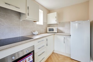 A modern kitchen with a built-in oven, microwave, and refrigerator. - Host & Stay | Theatre View (Darlington)